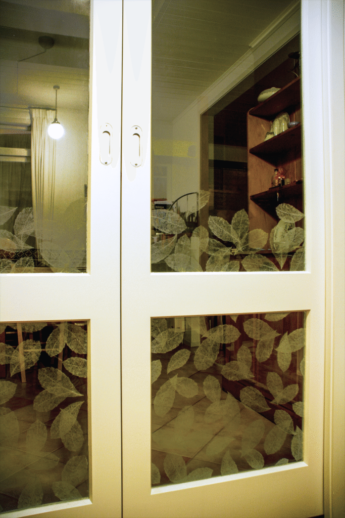 Sandblasted glass sliding doors dividing dining and living room